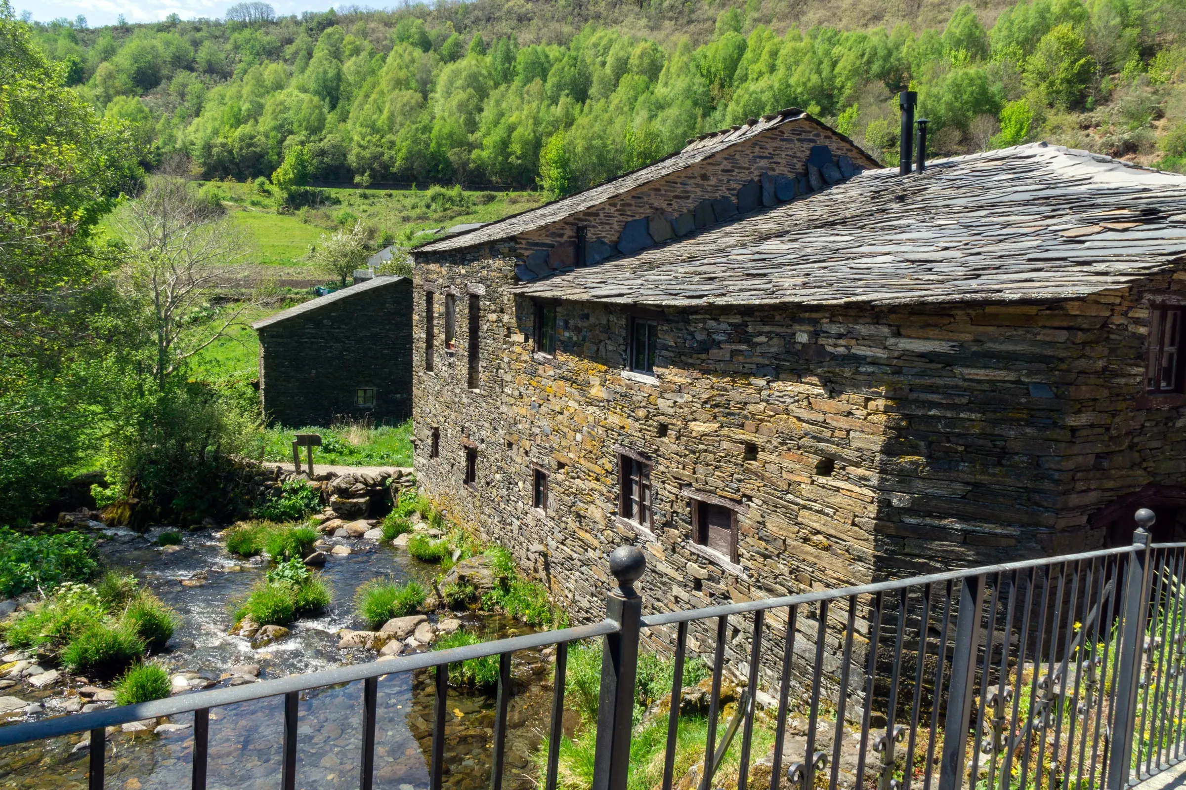 Casas de piedra y pizarra junto a un arroyo en la Serra do Courel, Lugo