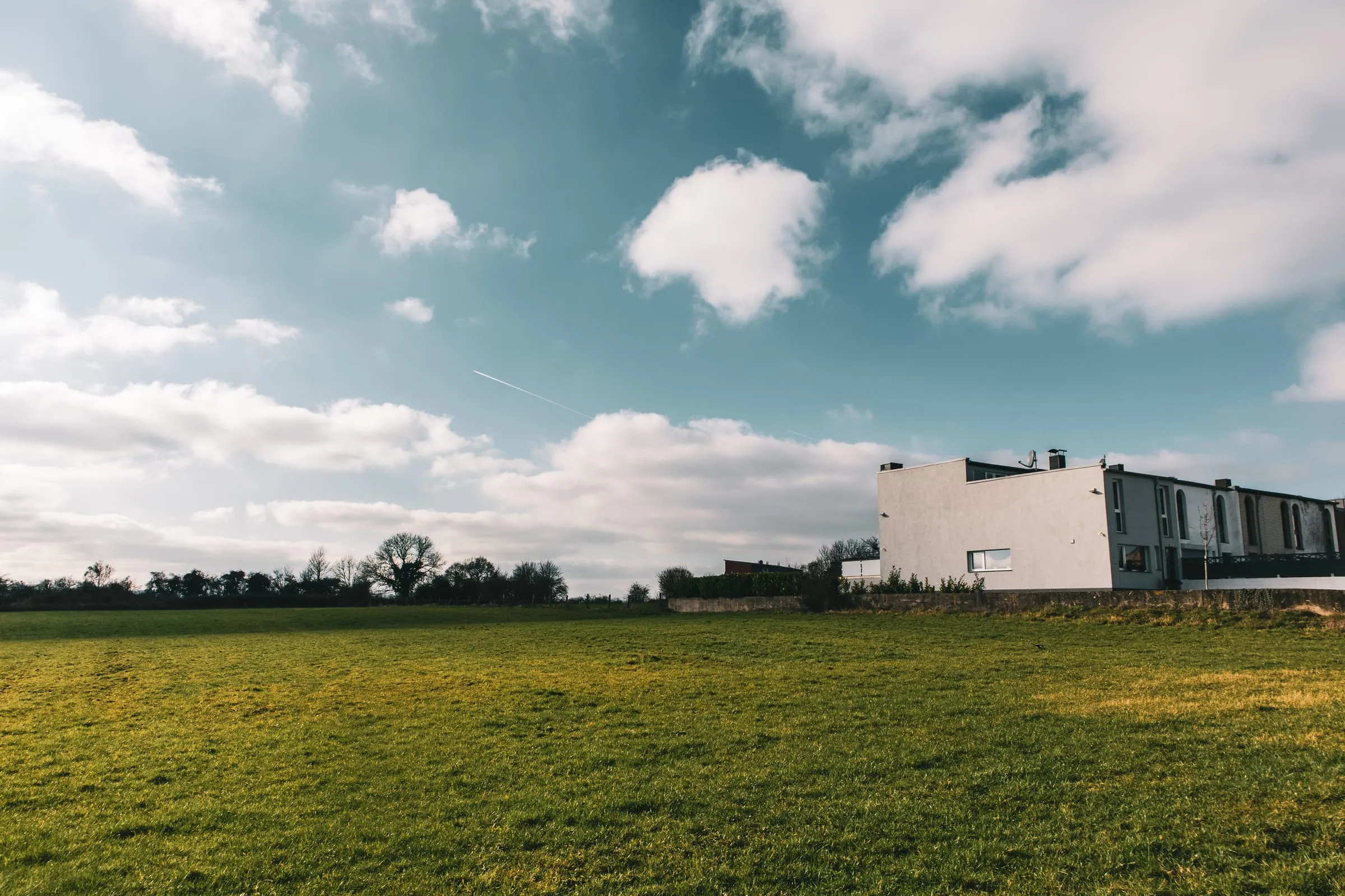 Edificación moderna de una planta en una parcela llana de pradera
