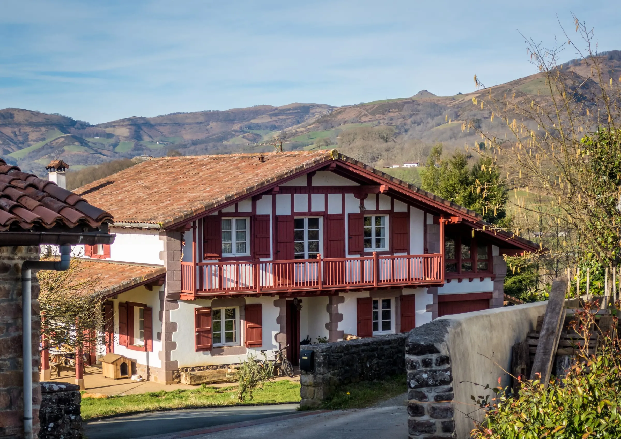 Casa tradicional de montaña con balcón de madera rodeada de montes