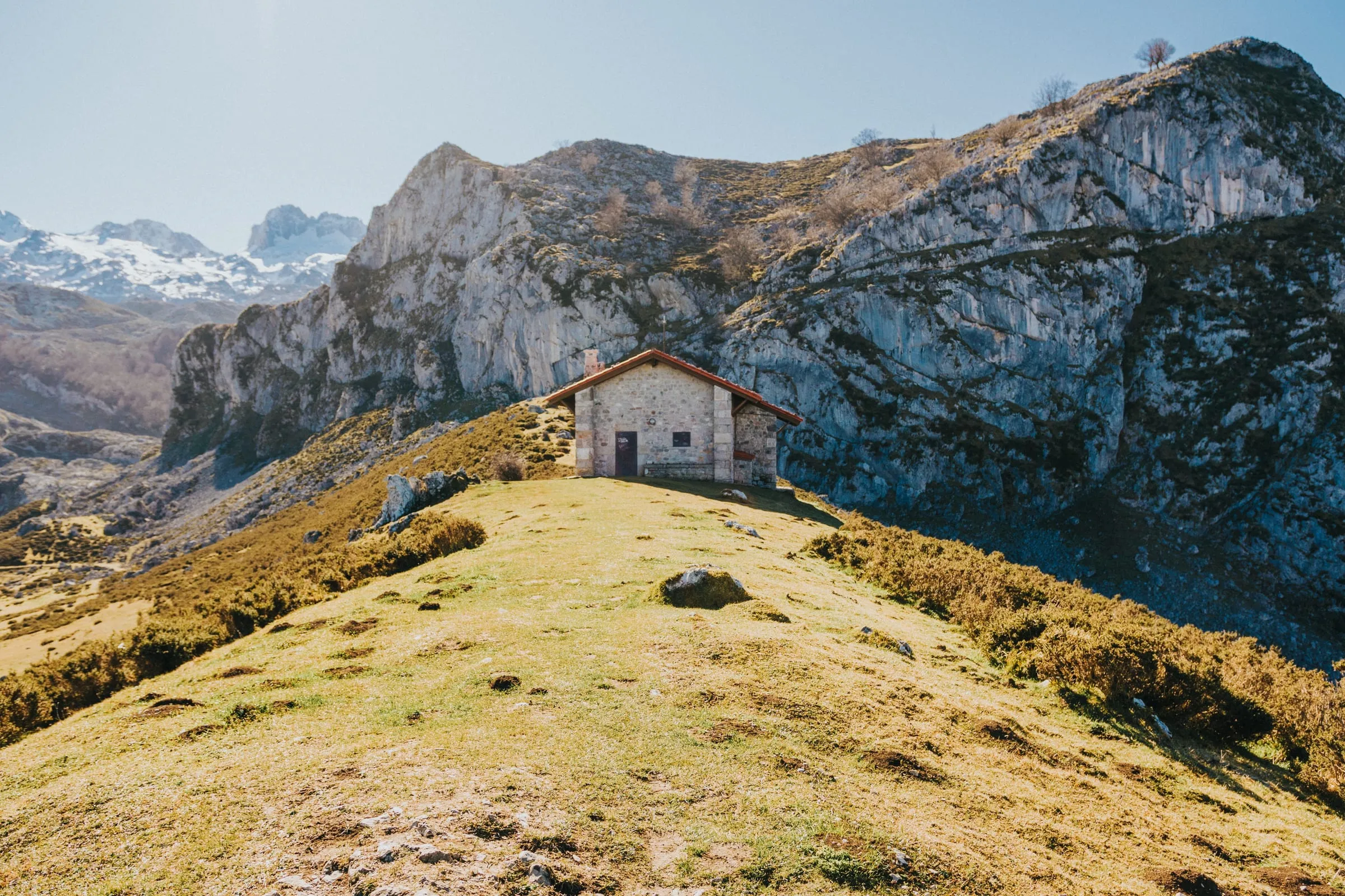Casa de piedra en lo alto de un prado de montaña