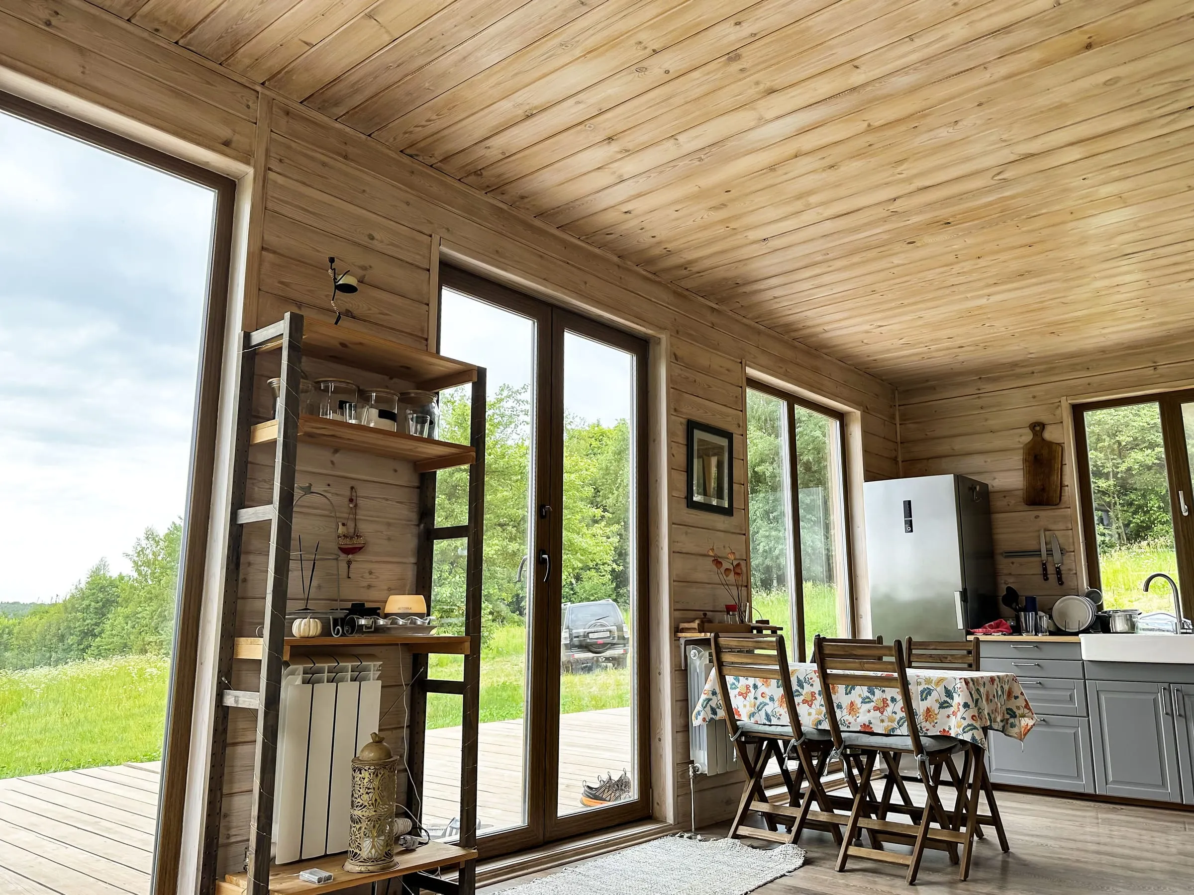 Interior de madera con ventanales panorámicos al campo