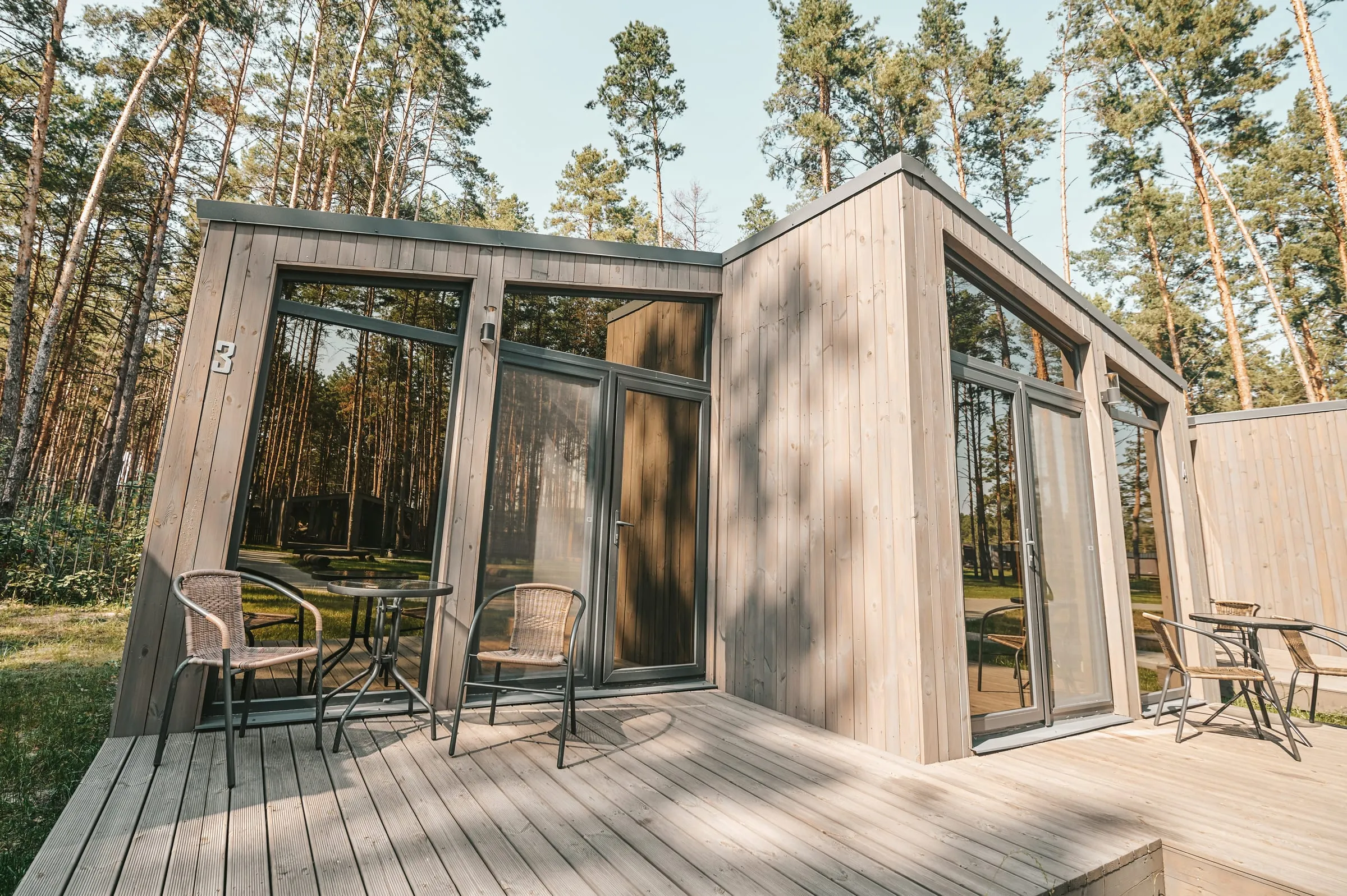 Módulo habitable de madera con terraza en un bosque de pinos