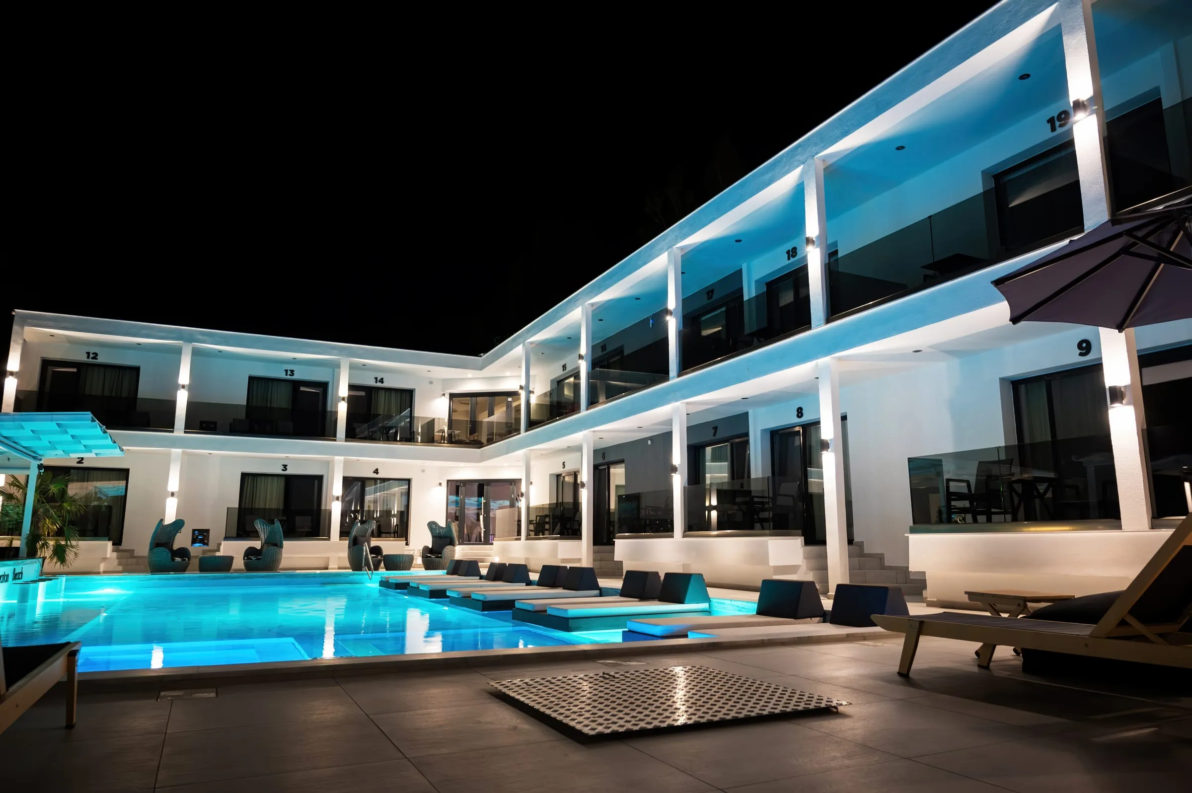 Vivienda moderna iluminada de noche junto a la piscina